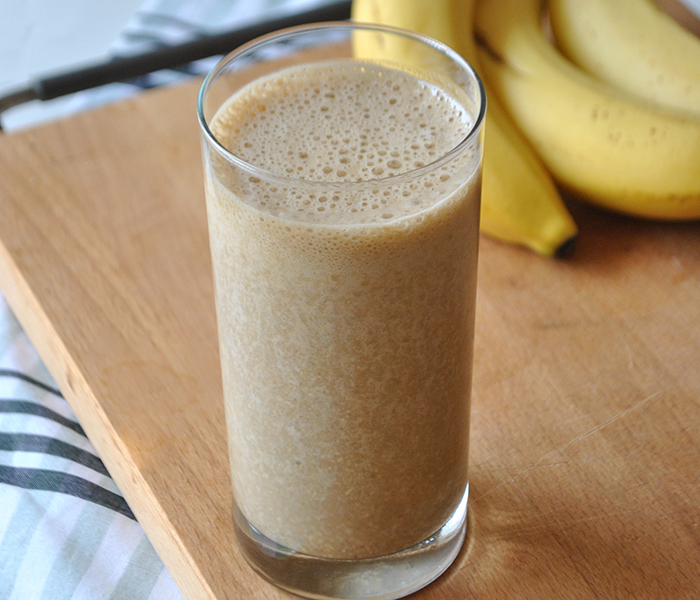 banana oat shake in a glass with bananas