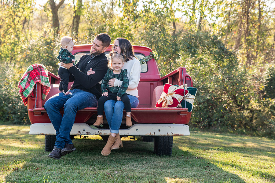 the omell family in a red truck outside