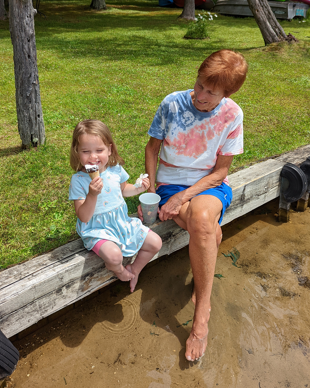 great grandma eating ice cream with great granddaughter