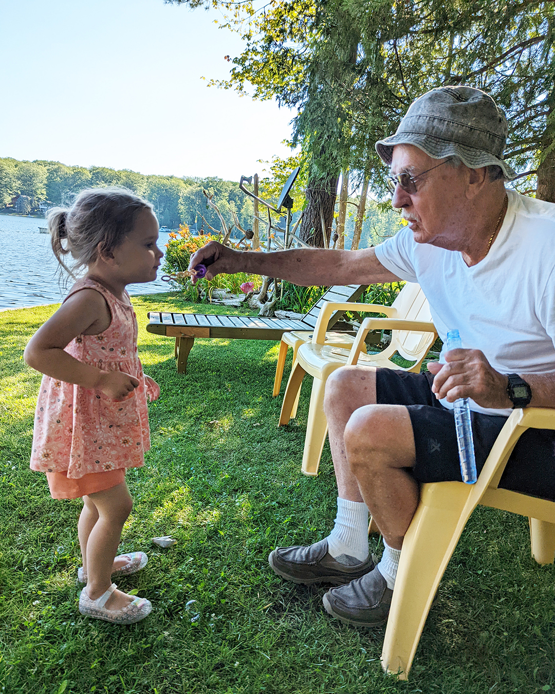 grandpa blowing bubbles with granddaughter